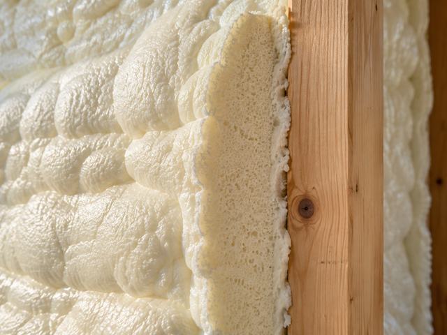 Cured closed-cell spray foam insulation filling a wall cavity